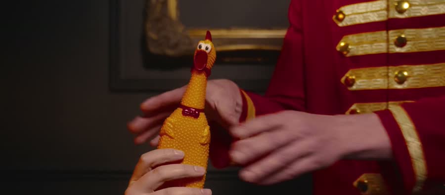 The bellhop holding a rubber chicken