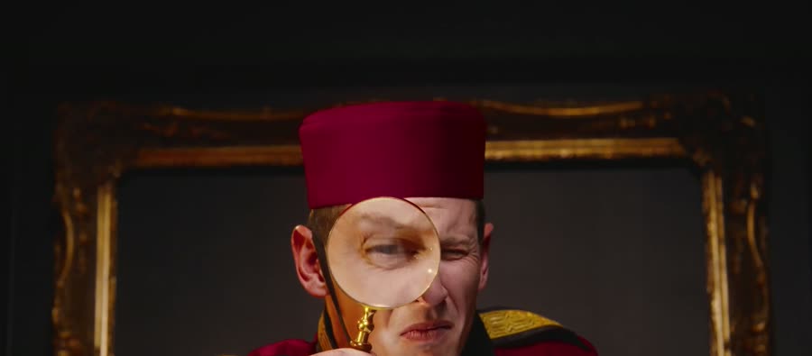The bellhop squinting through a magnifying glass